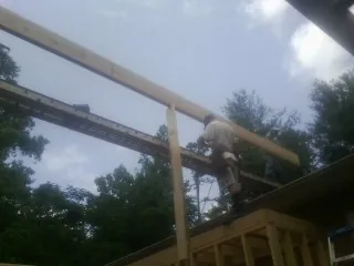Carpenter setting a ridge beam over a new addition frame — Ice Dam Removal by Roofing Brothers in Carnesville