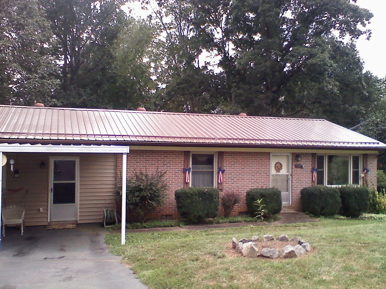 Bronze metal roof and carport on a brick ranch home — Roof Repair work by our crew in Carnesville